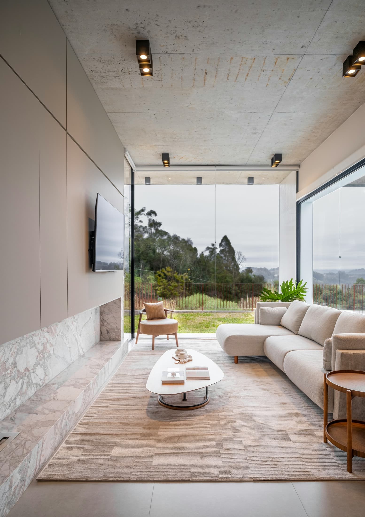 Living con ventanal de piso a cielo y vista a un jardín