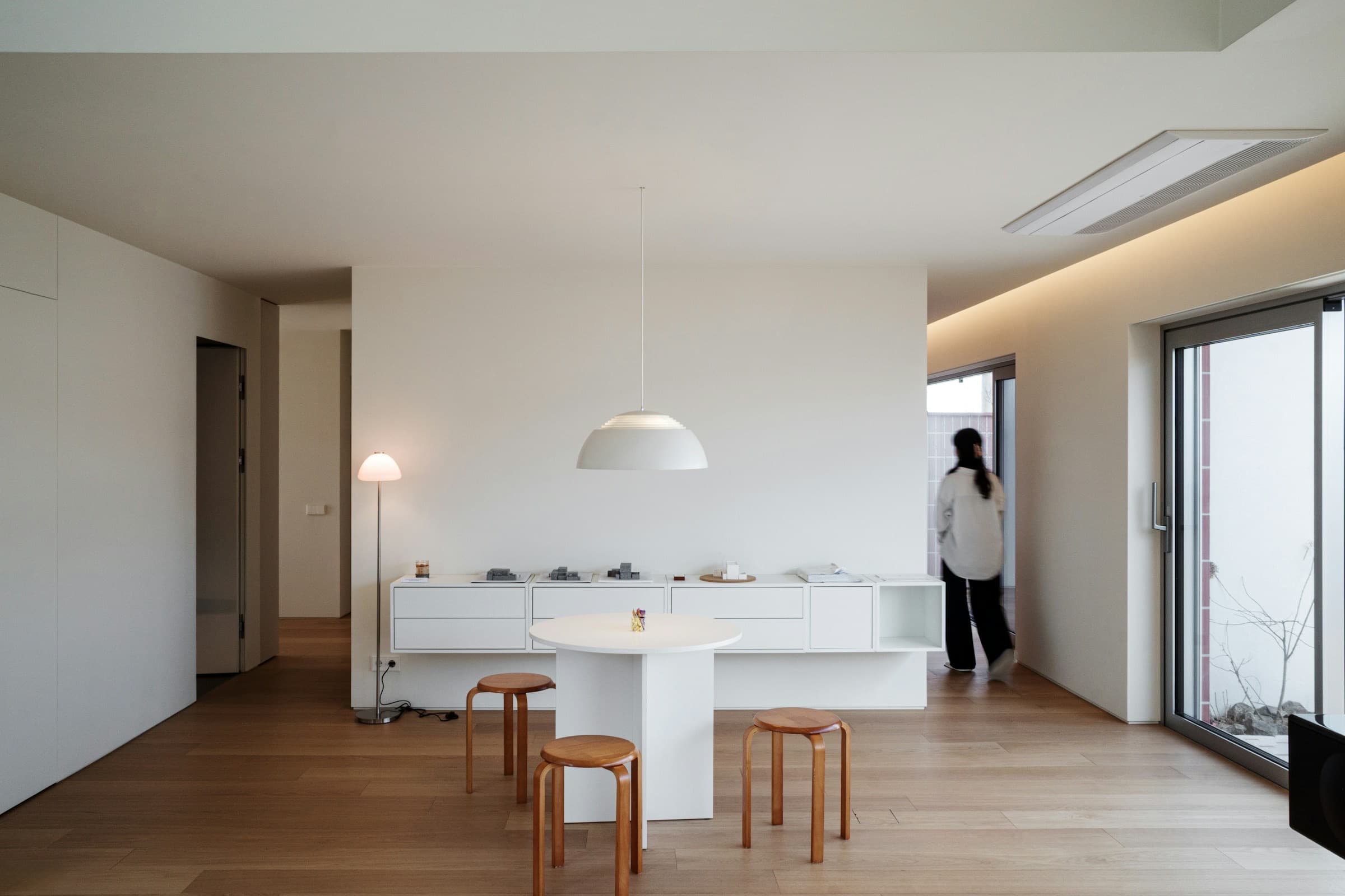 Comedor minimalista blanco con piso de madera